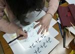 　繰り返し手で書いた平仮名を別の紙になぞる松本文字塾の受講生＝２０２４年４月、長野県松本市