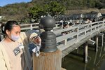 ぬれ雑巾で丁寧に橋を磨く児童ら＝１４日、鳥取市東町２丁目の擬宝珠橋