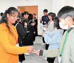 鳥取大の留学生（左）と英語でじゃんけんゲームを楽しむ子どもたち＝２日、新温泉町湯の町民センター