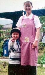 　三條すみゑさん（右）と、小学１年時の三男泰寛さん＝１９９９年、宮城県石巻市（三條さん提供）