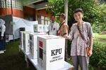 　インドネシア大統領選の投票箱の隣に立つ倉沢愛子慶応大名誉教授（右）＝２０２４年２月、ジャカルタ（共同）
