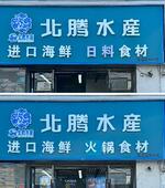 　海鮮市場で輸入水産物を扱う店に掲げられた看板。８月にあった日本料理を意味する「日料」の文字（上）は「火鍋」に書き換えられていた（共同）
