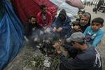 　１５日、パレスチナ自治区ガザ南部ハンユニスでテントの前に座るパレスチナ人ら（ゲッティ＝共同）