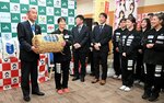 栗原会長（左）から星空舞を受け取る石田主将ら