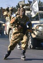 　公安警察の車両を先導するスケート部隊の隊員＝２０２３年１２月、アフガニスタン・カブール（共同）