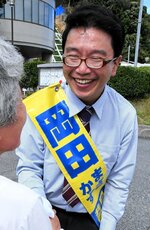 支援者と握手する岡田候補＝１５日、岩美町浦富の岩美町役場