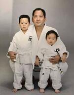 　幼少期に父の斉藤仁さん（中央）と記念撮影に納まる斉藤立（右）と兄の一郎さん（左）（母の三恵子さん提供）