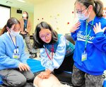 モンゴルの生徒（中央）と救急法を実演する学生ら＝２０日、鳥取看護大