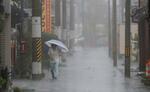 　台風７号の影響で強い雨が降る和歌山県田辺市内を歩く人＝１５日午前８時５２分