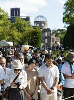　被爆から７８年を迎え、原爆投下時刻に黙とうする人たち。奥は原爆ドーム＝６日午前８時１５分、広島市の平和記念公園