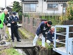 事故が発生した水門周辺を確認する関係者ら＝２５日、倉吉市国府