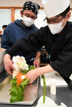 参加者（左）が作ったむきものを仕上げる講師