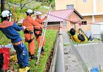 水害を想定した訓練でロープを使って救助される教諭（右）＝１０月３１日、新温泉町湯の温泉小