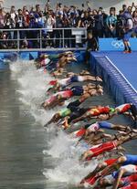 　パリ五輪のトライアスロン男子でスタートする選手たち。セーヌ川の水質問題で延期となった末、基準をクリアし実施された＝３１日、パリ（共同）