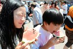 甘くてみずみずしい県産スイカを頬張る来場者＝１７日、鳥取市賀露町西３丁目の地場産プラザわったいな