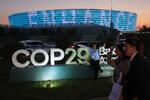 　ＣＯＰ２９の会場前で写真撮影をする人たち＝１５日、バクー（ゲッティ＝共同）