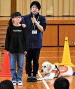 盲導犬に代わり、視覚障害者の道案内に挑戦する鹿野学園の児童（左）