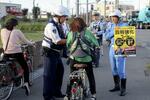 　昨年１０月、自転車走行中の携帯電話使用などに罰則を新設した改正道交法の施行を前に、新たなルールを周知する埼玉県警の警察官ら＝埼玉県草加市