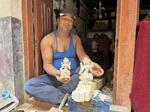 　ヒンズー教の女神像とネパールの首都近郊ブンガマティの木彫り職人サンプワナ・マハルジャンさん＝２０２４年６月（共同）