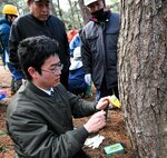 薬剤の入ったボトルを差し込む参加者＝１３日、北栄町田井の北条オートキャンプ場