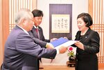 李会長（右）に要望書を手渡す藤井会長ら＝２６日、韓国・春川市内