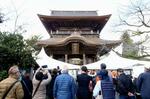 　復旧した阿蘇神社の楼門を訪れた人たち＝７日午前、熊本県阿蘇市