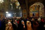 　ウクライナの首都キーウの聖ミハイル黄金ドーム修道院で、クリスマスイブに祈りをささげる人々＝２４日（ロイター＝共同）