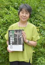 　捕虜収容所・民間人抑留所事典を手にする笹本妙子さん