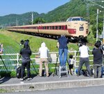 ３８１系「国鉄色」の最後の雄姿をカメラに収めるファンら＝６月１４日、日野町下榎