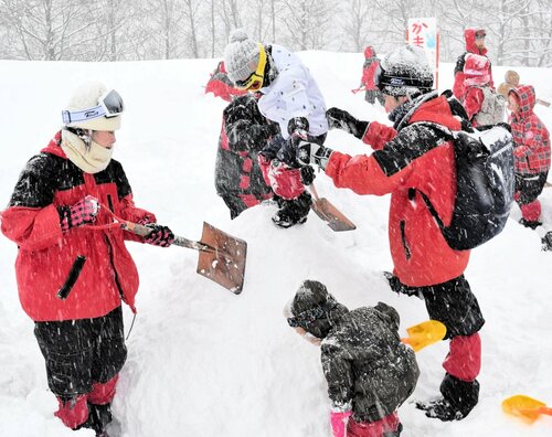 かまくら作りを楽しむ家族連れ＝８日、香美町小代区新屋の尼崎市立美方高原自然の家「とちのき村」