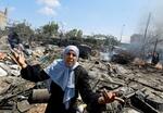 　１３日、パレスチナ自治区ガザ南部ハンユニスで、破壊された難民キャンプに立つ女性（ロイター＝共同）