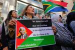 　南アフリカの故マンデラ元大統領の顔写真をあしらったパレスチナ旗を掲げる女性＝１９日、レバノン・ベイルート（ＡＰ＝共同）