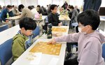 真剣勝負を繰り広げる子どもたち＝２日、鳥取市富安２丁目の日本海新聞ビル５階ホール