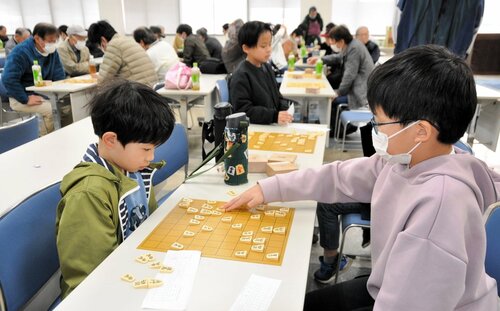 真剣勝負を繰り広げる子どもたち＝２日、鳥取市富安２丁目の日本海新聞ビル５階ホール