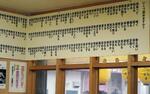 　明石焼き店「ゴ」の店内の壁一面に並ぶ漢字。読み方を全て正解すると明石焼きが１年間無料になるサービスがある＝２０２４年２月、兵庫県明石市