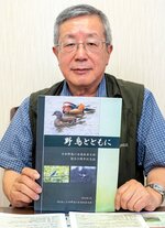 ３０周年記念誌「野鳥とともに」を手にする田中編集委員長