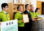 表彰を報告し記念撮影する会下部落地域資源・環境保全プロジェクトのメンバーら＝鳥取市役所