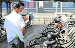 自転車の施錠状況を確認する高校生ボランティア＝１０日、ＪＲ倉吉駅南口駐輪場