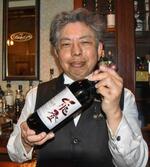 　「能登ワイン」の「ＮｓｅｌｅｃＴヤマソーヴィニヨン」を手にする中家弘樹さん＝２７日、鳥取県倉吉市
