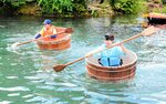 たらいのバランスを取りながら懸命にオールを動かす出場者＝１０日、新温泉町石橋の石橋池