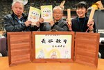 完成した紙芝居と冊子を手に喜ぶ田中会長（中央）ら＝６日、鳥取市佐治町加瀬木の同町総合支所