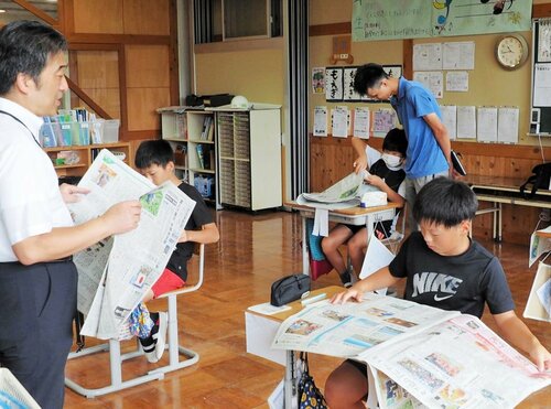 中村記者（左）から新聞の楽しさを学ぶ児童たち＝２６日、新温泉町高末の浜坂東小