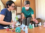 ２代目の張り子人形と見比べながら、宮子さん（右）に絵付けのこつを聞く文さん