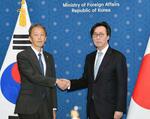　５日、韓国・ソウルで「戦略対話」に先立ち、握手する岡野正敬外務事務次官（左）と韓国の張虎鎮外務第１次官（共同）