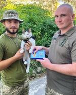 　ウクライナ軍に貢献したとして賞を授けられたネコと、飼い主のオレクサンドル・リャシュクさん（左）＝９月、ウクライナ南部（リャシュクさん提供・共同）