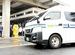 職員らに見守られ島根県庁を出発する投票用紙を載せた車両＝２５日、松江市殿町
