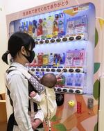 　自動販売機で紙おむつを購入する女性＝横浜市（ＮＰＯ法人「こまちぷらす」提供）