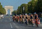 　トライアスロン女子のパリ五輪テスト大会で、シャンゼリゼ通りをバイクで疾走する選手たち＝昨年８月、パリ（ＡＰ＝共同）