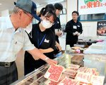 来客（左）に豚肉の説明をする生徒たち＝１５日、琴浦町逢束の鳥取東伯ミート直販店