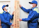 事務所に看板を掲げる平井知事（左）と奥本事務所長＝２２日、鳥取市佐治町加瀬木